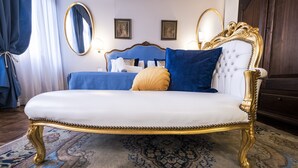 A luxurious bed with a white and gold frame, blue bedding, and a decorative pillow. - Ca' Lavezzera (Venice)