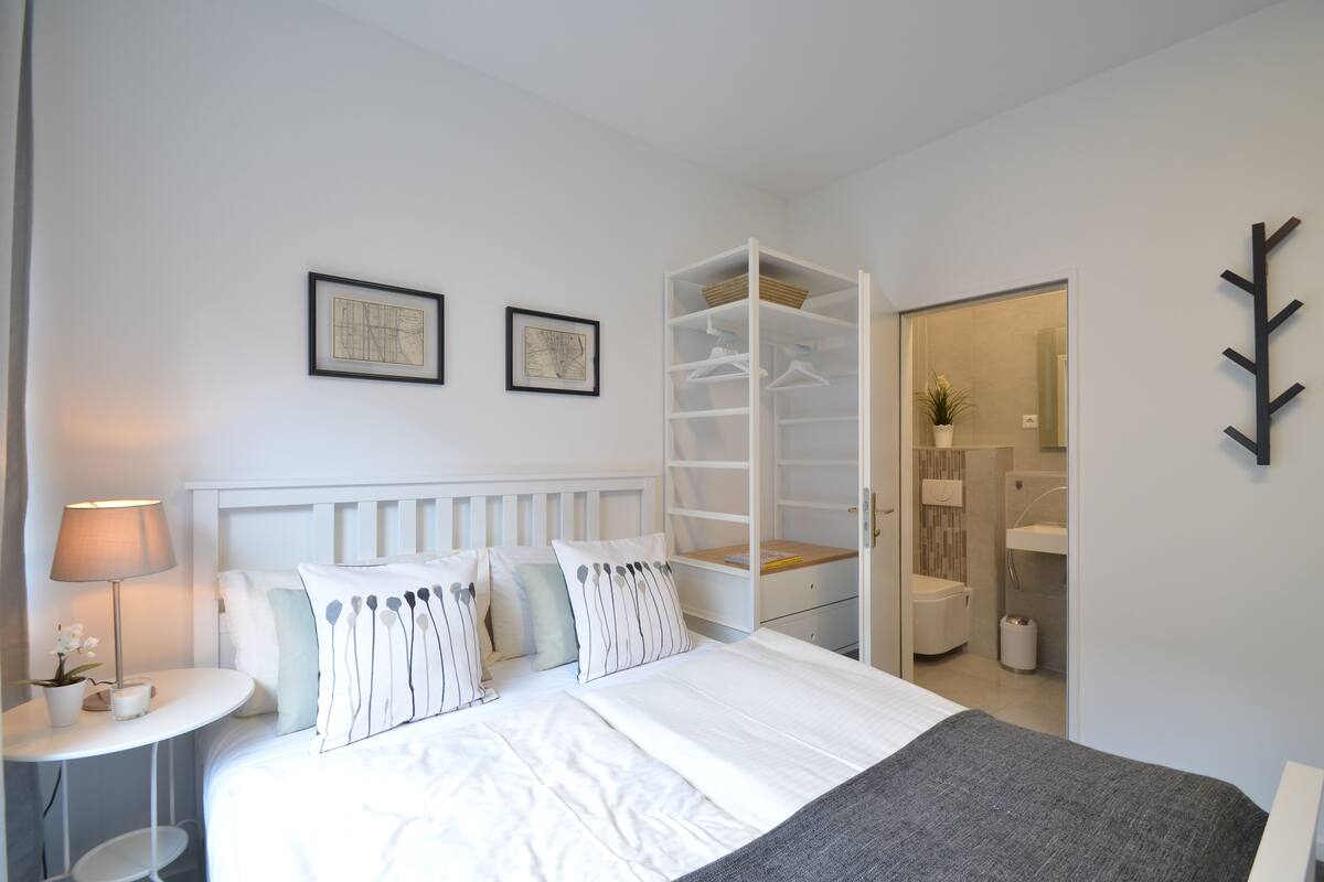 Un dormitorio con cama, mesita de noche y armario.