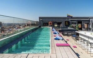 Una piscina al aire libre, sombrillas, tumbonas