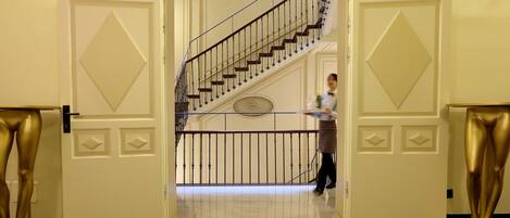 A grand staircase with a handrail and a decorative wall panel.