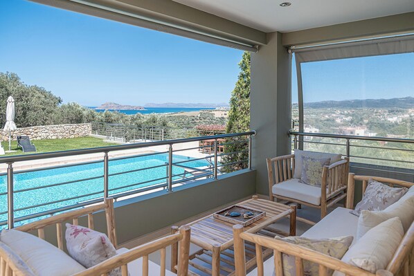 A balcony with a view of a swimming pool and the sea. - Villa Athinais (Platanias)