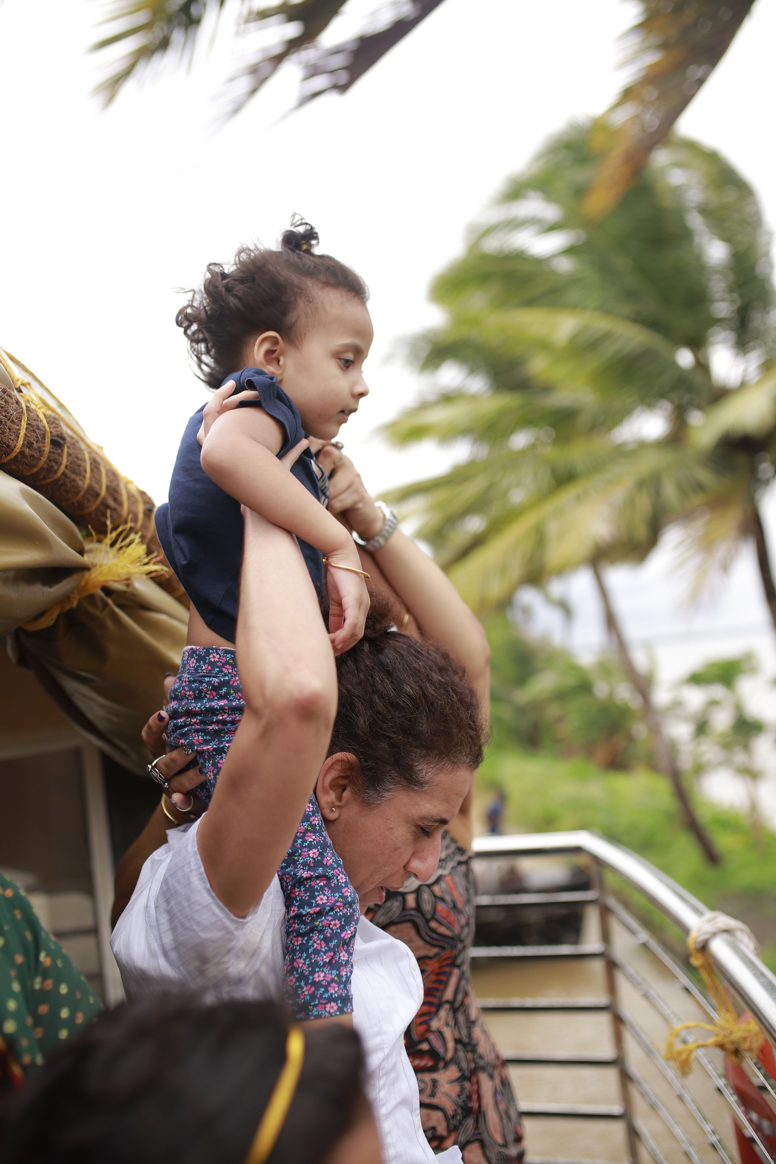 Une personne qui porte un enfant sur ses épaules.