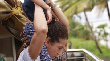 Une personne qui porte un enfant sur ses épaules.