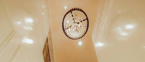 Una escalera con paredes blancas y barandilla de madera que conduce a una plataforma con baranda de metal.