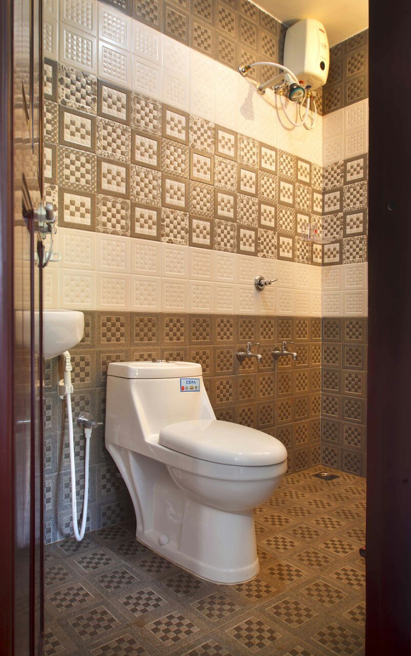 A bathroom with a toilet, a shower, and a hand dryer.