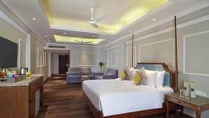 A hotel room with a large bed, a desk, a sofa, and a TV. - Hotel Swosti Premium (Bhubaneshwar)