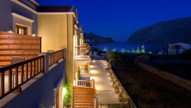 Un hotel con balcón con vistas a un puerto deportivo y al mar.