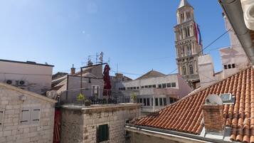 A view of a cityscape with a prominent tower and a building with a red roof.
