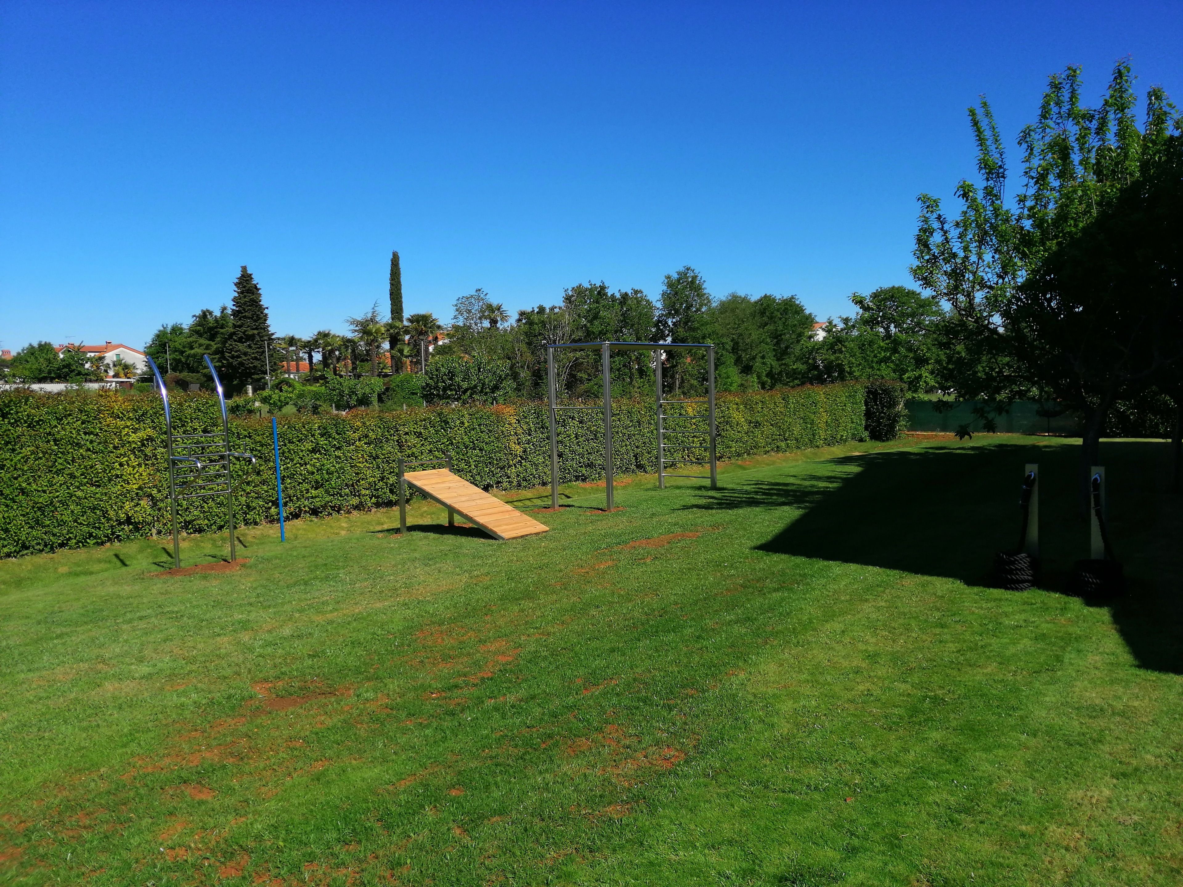 A playground with a slide, climbing structures, and a fenced area.