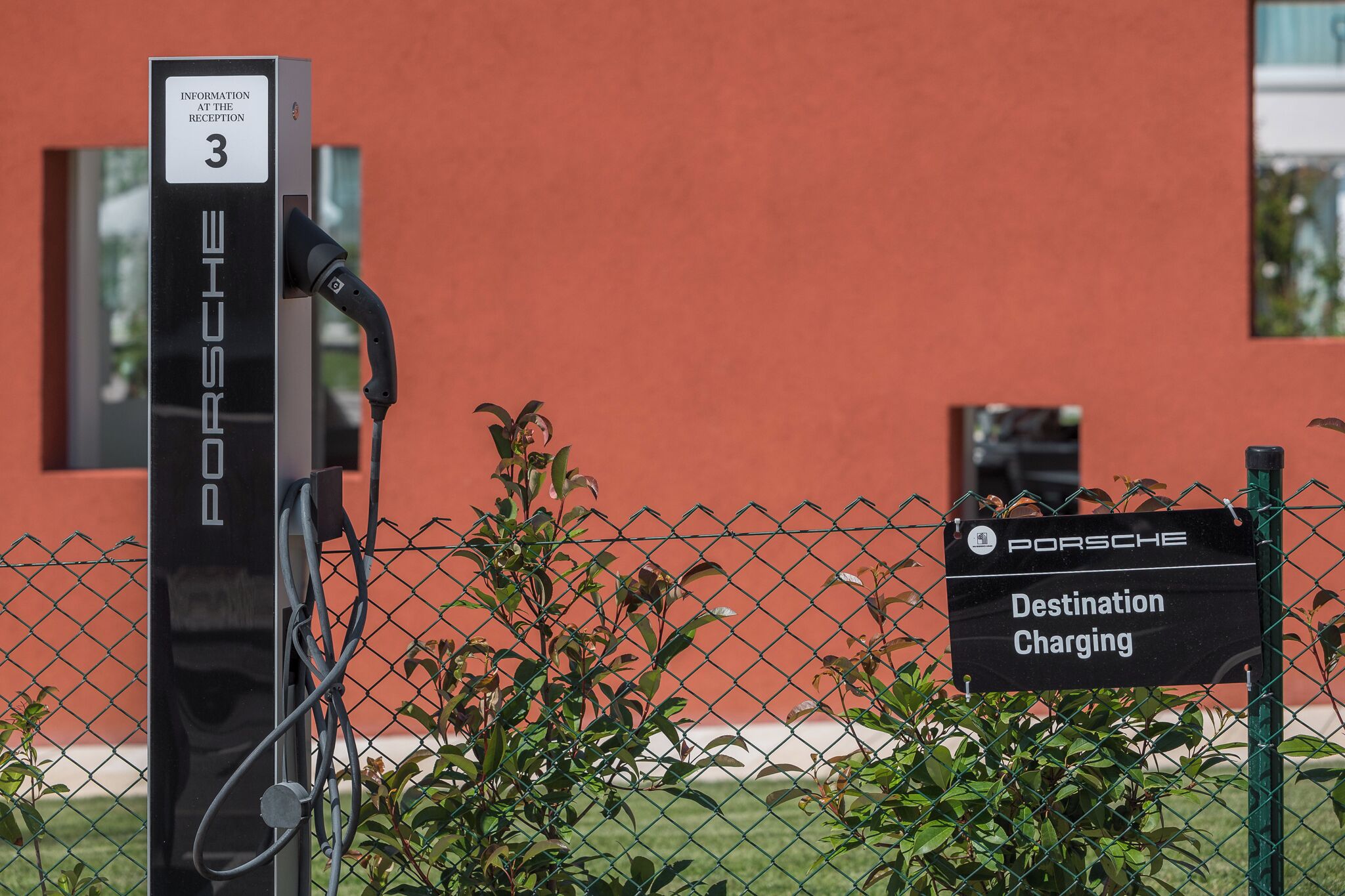 Eine Ladestation mit einem Schild, das angibt, dass sie für das Porsche Destination Charging gedacht ist.
