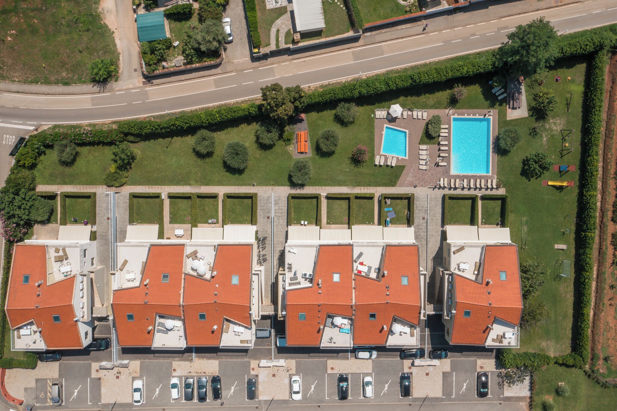 Eine Wohngegend mit einer Reihe von Häusern, einem Schwimmbad und einem Parkplatz.