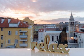 A view of a cityscape with buildings and a 'relax' sign in the foreground.