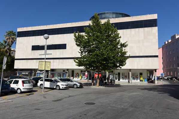 A modern building with a flat facade, large windows, and a central tree.