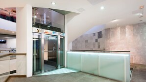 A modern elevator area with glass doors and a digital display indicating the floor level. - PRIMA Life Spalato (Split)