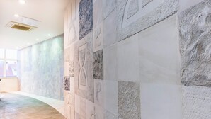 A hallway with a textured wall and a tiled floor. - PRIMA Life Spalato (Split)