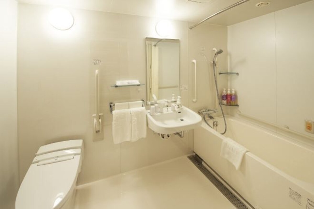 A modern bathroom with a toilet, sink, and bathtub.