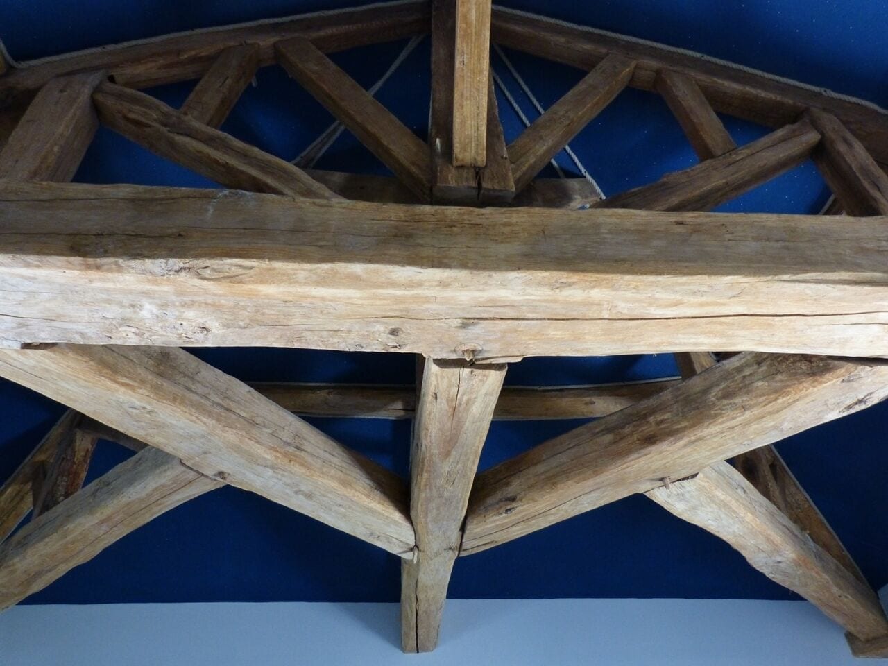 A wooden structure with a triangular framework, possibly a part of a building's architecture.