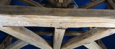 A wooden structure with a triangular framework, possibly a part of a building's architecture.
