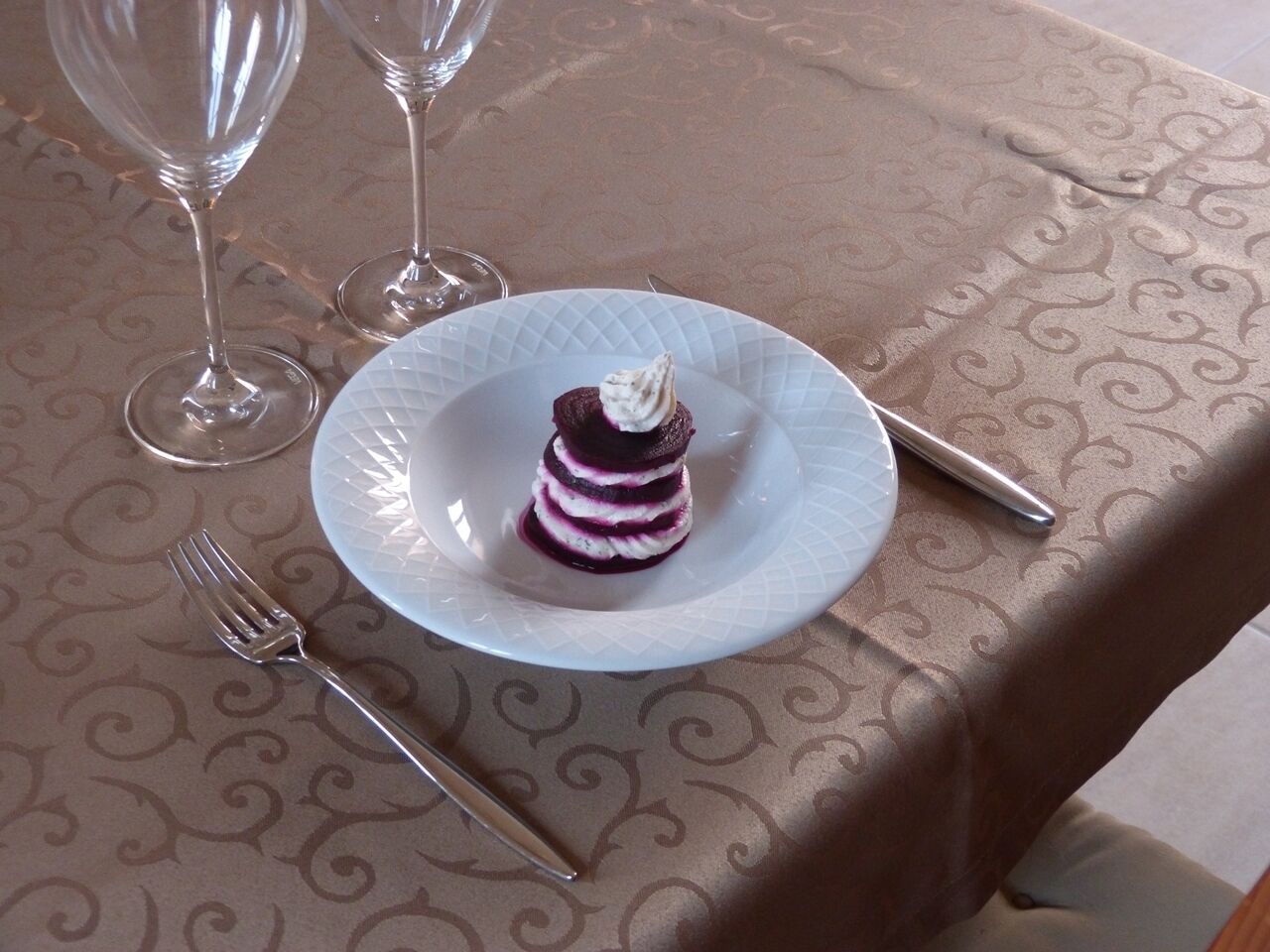 A table set with a plate of dessert, a fork, and a knife.