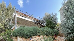 A stone wall with a metal staircase leading to a balcony. - Kaktus Beach Apart (Kas)