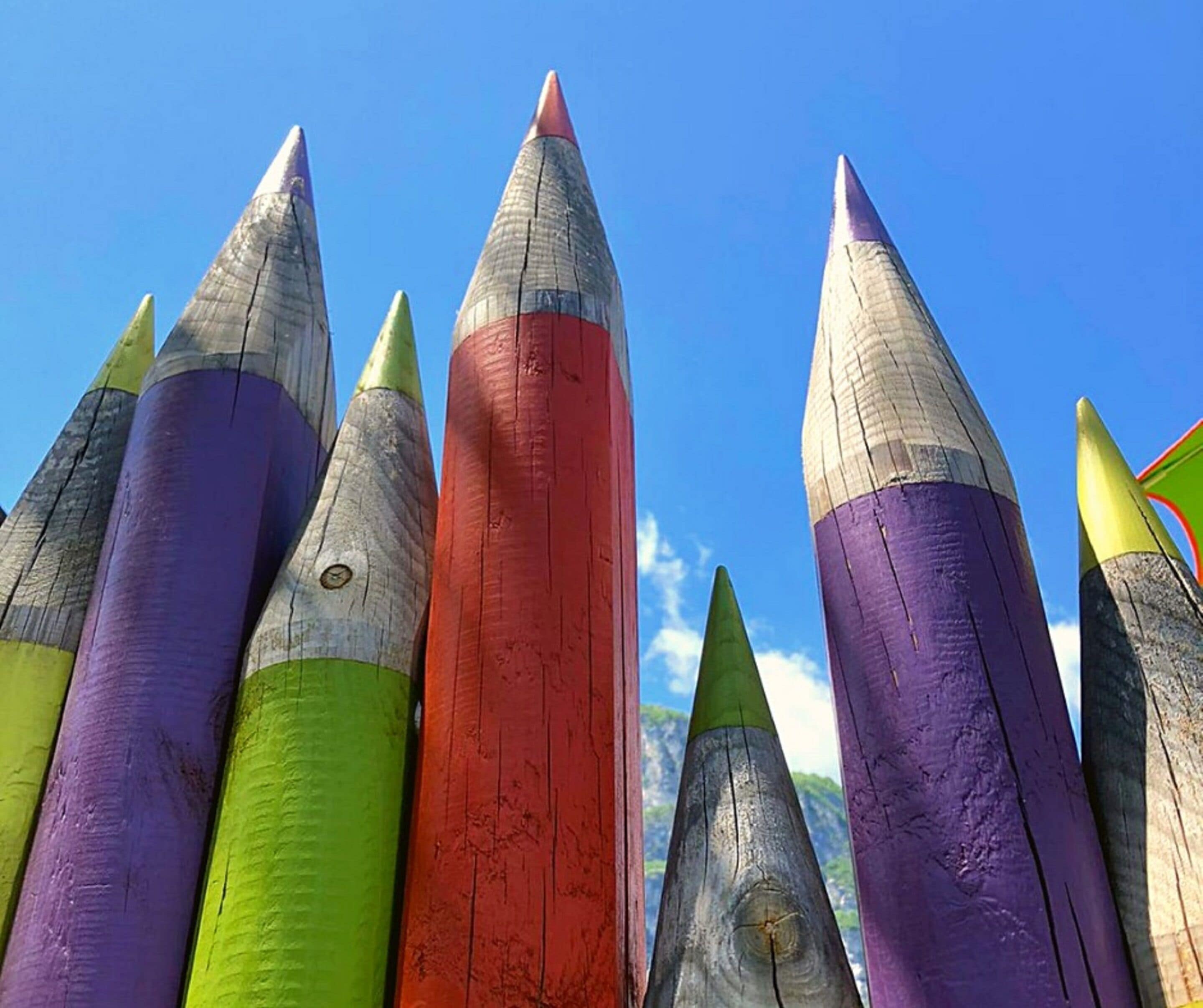 A collection of colorful pencil-like objects against a clear blue sky.