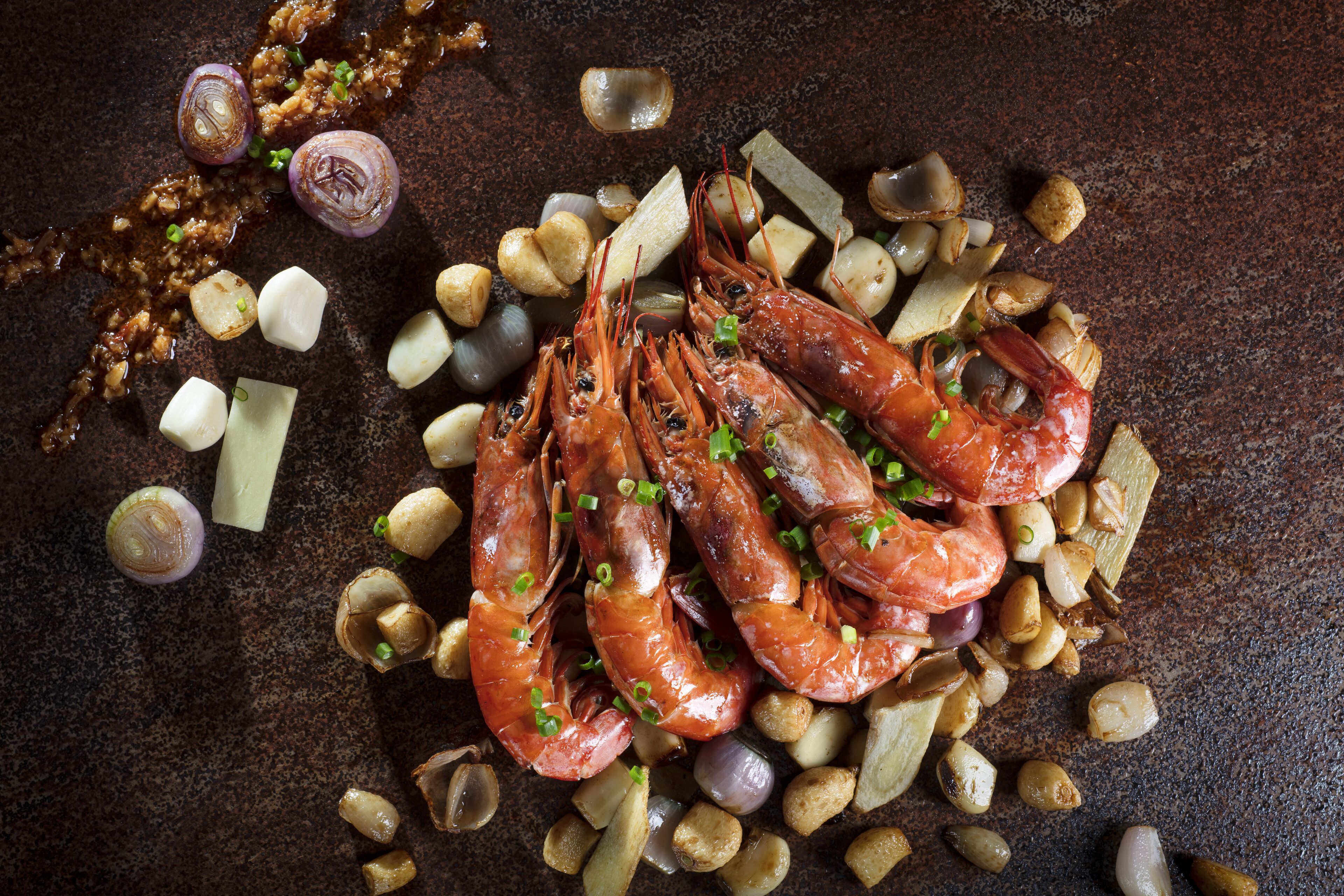 A dish of cooked shrimp with garlic and onions.