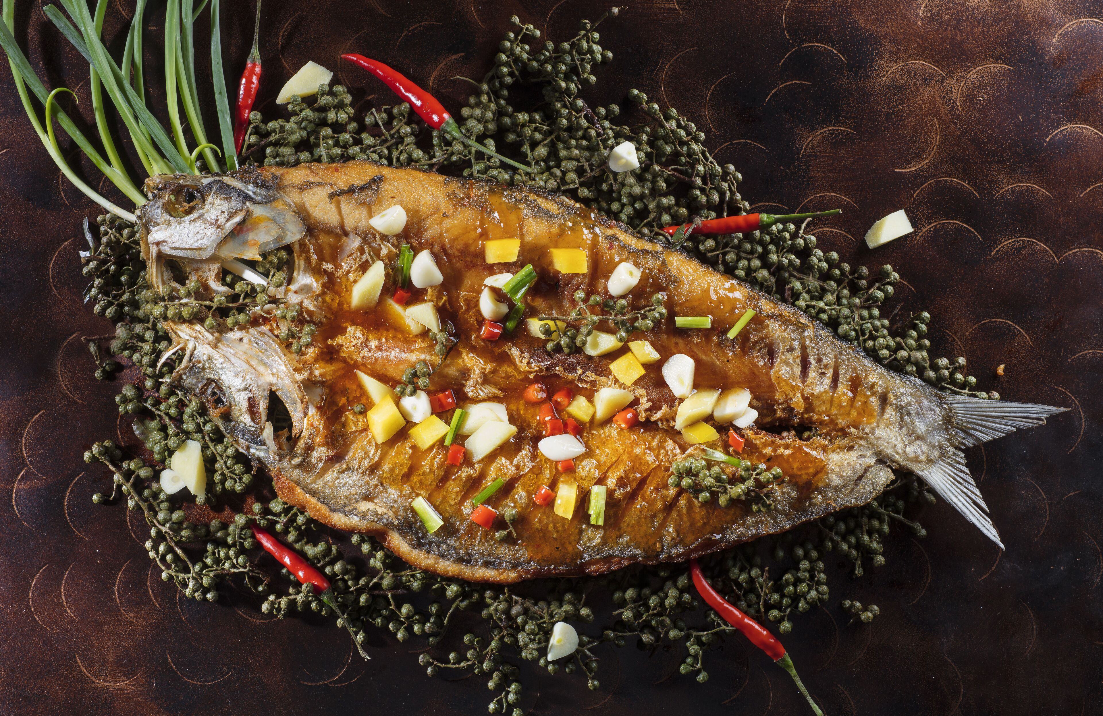 Ein ganzer Fisch, dekoriert mit Gemüse und Kräutern.