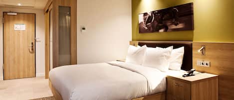 Una camera d'albergo moderna con un letto in legno, un comodino e un'opera d'arte appesa al muro.