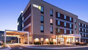 A modern hotel with a covered entrance, multiple floors, and a sign indicating it is a Home2 Suites by Hilton. - Home2 Suites by Hilton Merrillville (Merrillville)