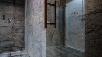 Experience a luxurious bathroom with a minimalist design, featuring a glass shower enclosure and a simple layout.