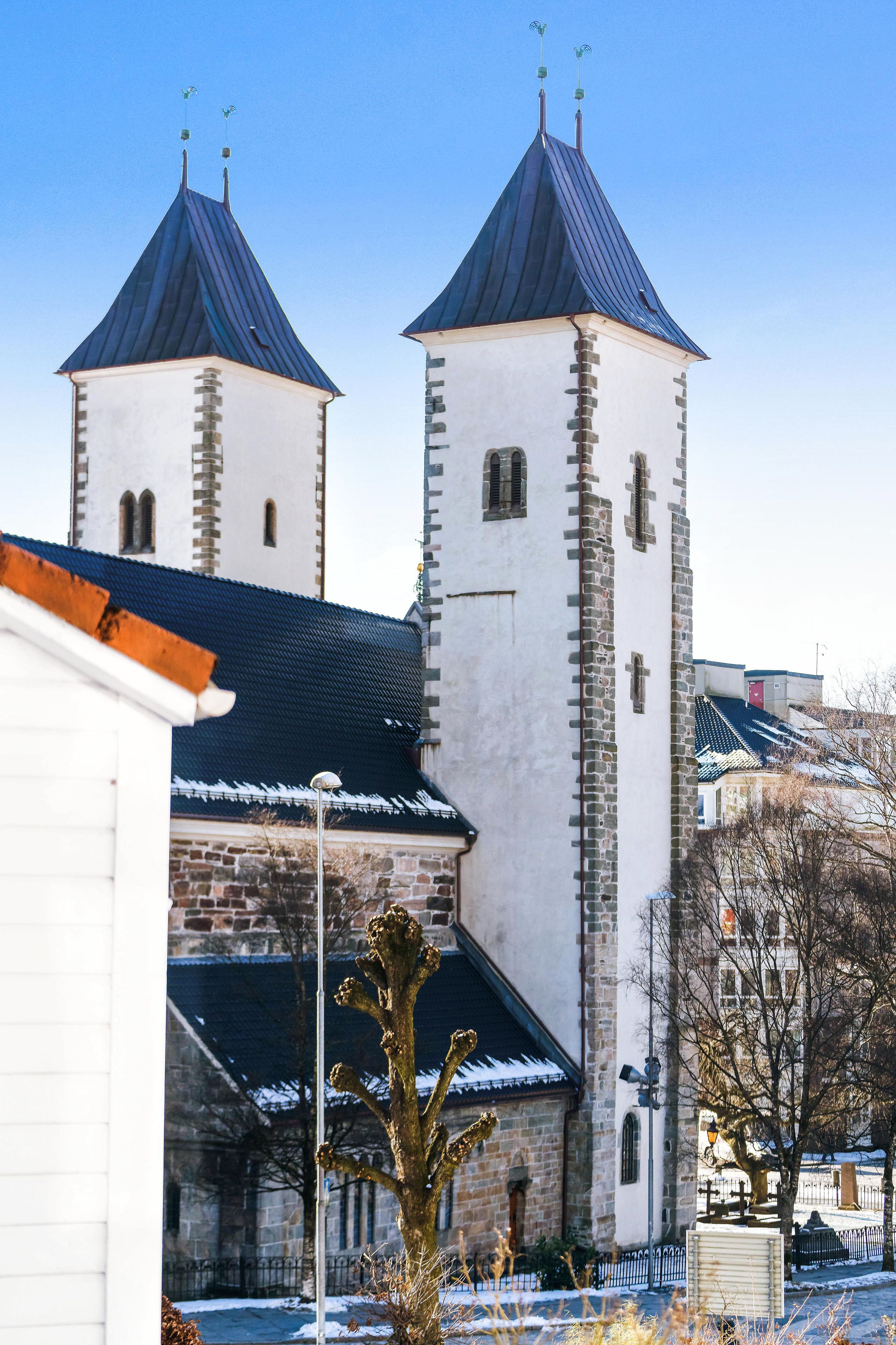 Une église dotée de deux tours et d’une façade blanche.