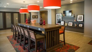 A conference room with a long table, multiple chairs, and red pendant lights. - Hampton Inn Pontiac (Pontiac)