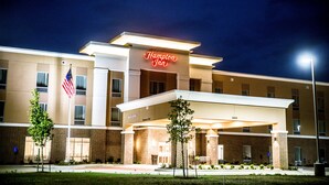 A Hampton Inn hotel with a well-lit entrance, American flag, and a clear view of the building's facade. - Hampton Inn Pontiac (Pontiac)