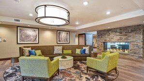 A modern living room with a stone fireplace, a sofa set, and a round coffee table.