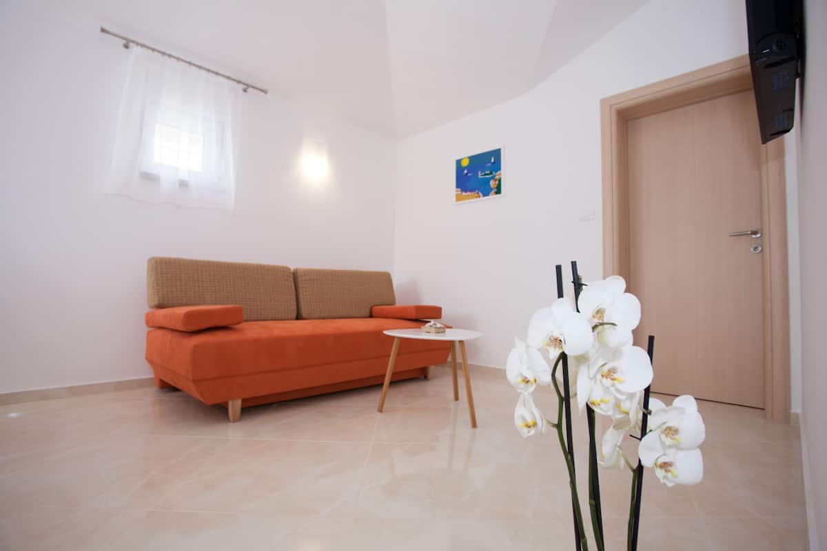 A modern living room with a sofa, a small round table, and a door.