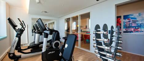 A gym with cardio machines, weightlifting equipment, and a dining area visible through glass doors.