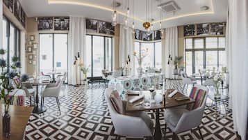 A modern dining area with geometric patterned flooring, round tables, and contemporary chairs.