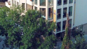 Un hotel de varios pisos con balcones, ventanas amplias y una antena parabólica.