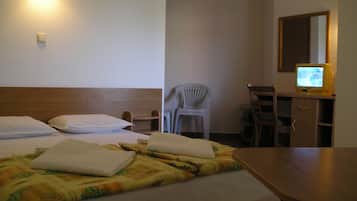A hotel room with two beds, a desk with a computer, a chair, and a mirror.