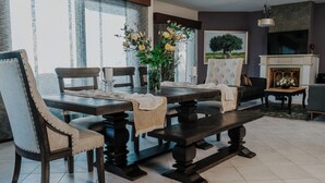 A dining area with a dark wooden table, chairs, and a vase of flowers. - Villa Artemis, Wine Dark Sea Villas (Malevizi)