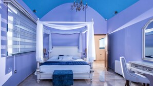 Um quarto com uma cama de dossel, uma penteadeira com espelho e uma escrivaninha.