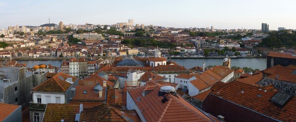 A cityscape with a river, historic buildings, and a prominent tower. - Casa Sao Miguel 6 (Porto)
