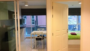 A modern apartment with a kitchen, dining area, and balcony. - Chateau In Town By Renvio (Bangkok)