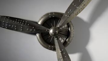 Un ventilador de techo con cuatro aspas y un centro giratorio.