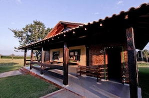 A rustic building with a brick exterior, wooden beams, and a covered porch. - Hotel Fazenda Vida Bela (Cesario Lange)