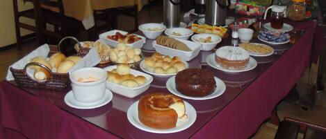 Une table de buffet proposant une variété de produits de boulangerie et de boissons.