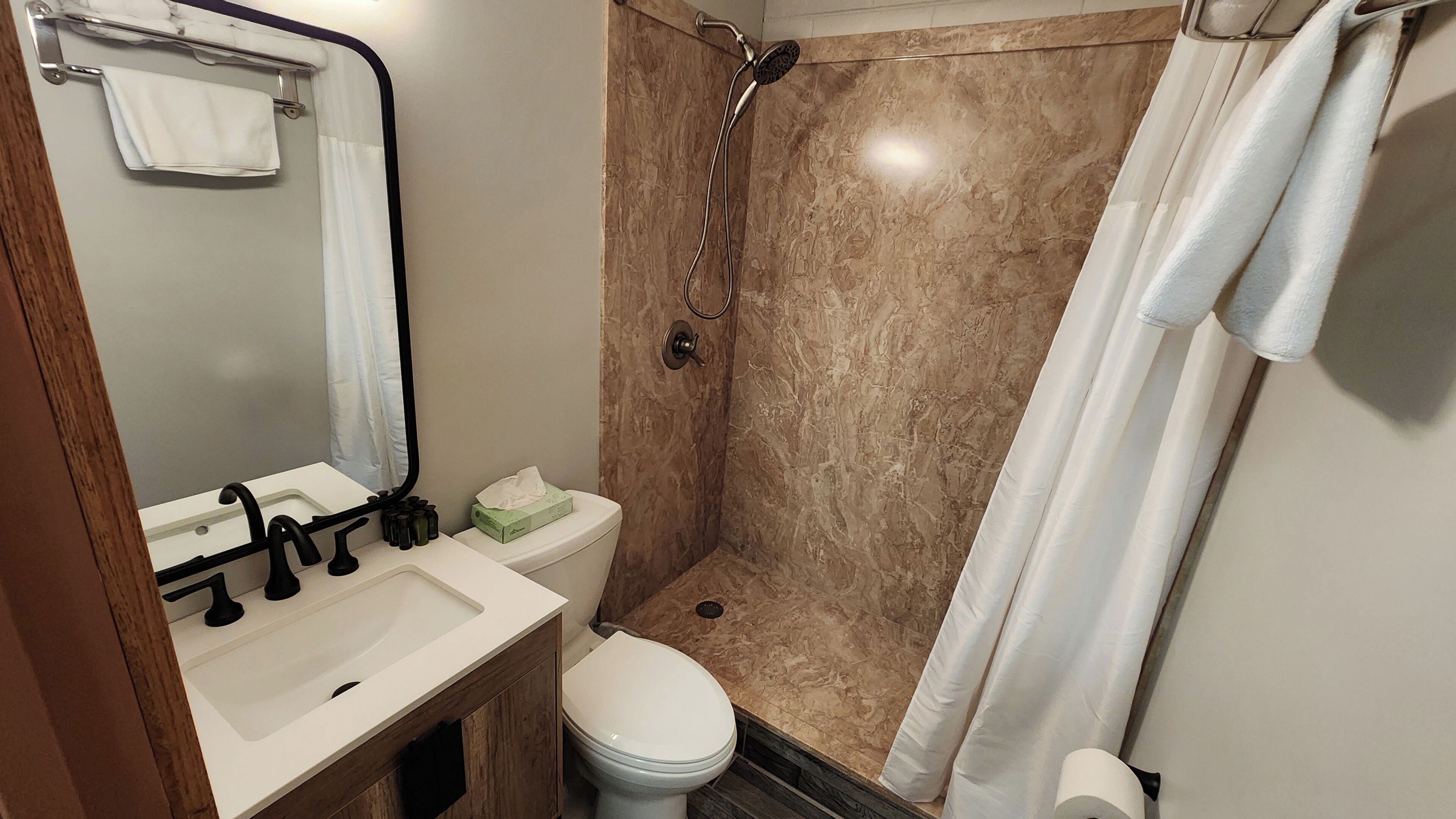 A bathroom with a sink, toilet, and shower.