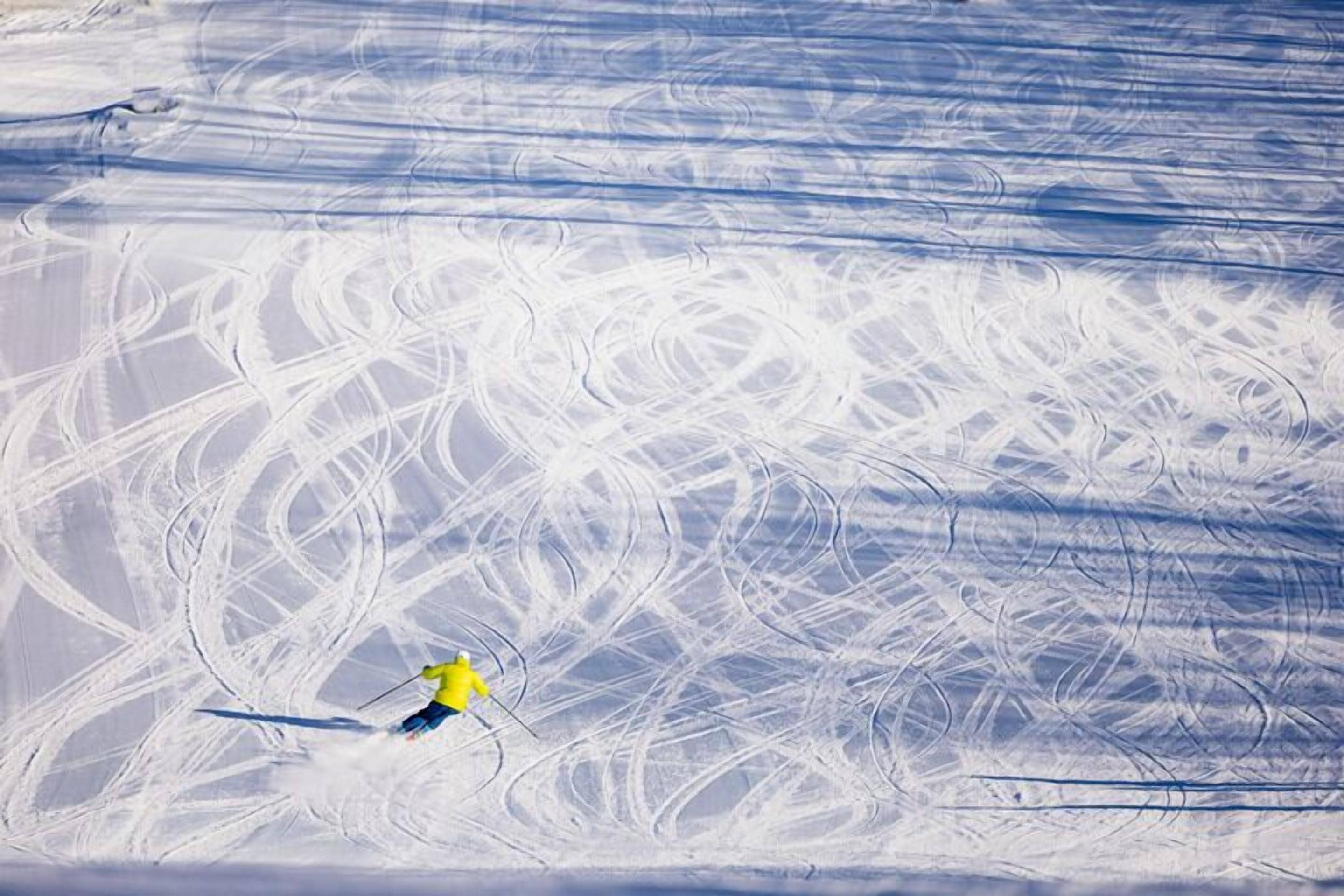 A snowy landscape with ski tracks.