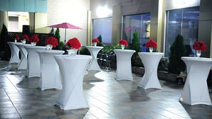 A series of white tables with red flowers, arranged in a row on a tiled floor. - Tomreik Hotel (Accra)