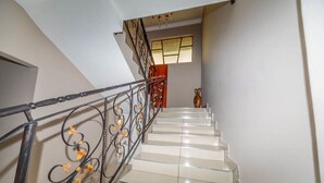 A staircase with a metal railing and a vase on the landing. - The Musafer Travel Lodge (Pietermaritzburg)